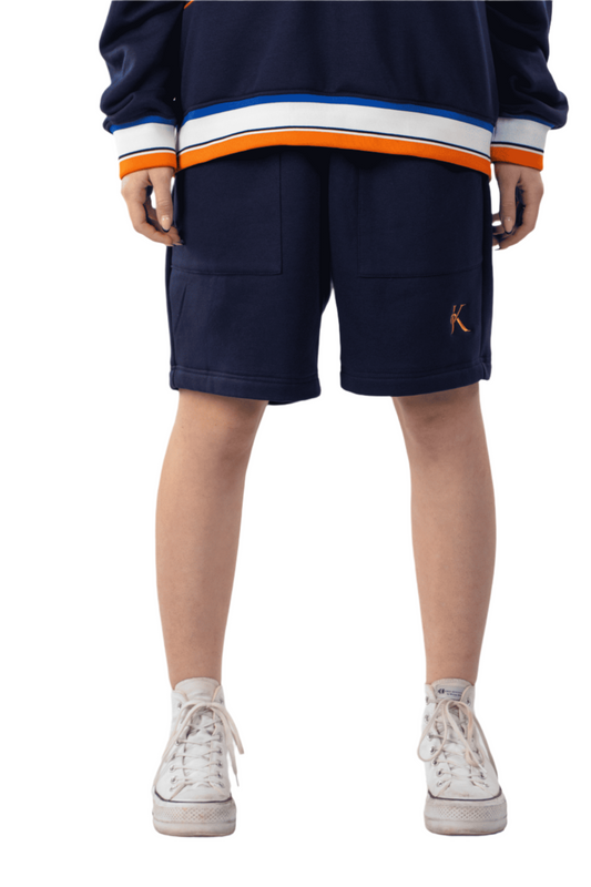 Person wearing a navy blue outfit with orange and white accents on a white background
